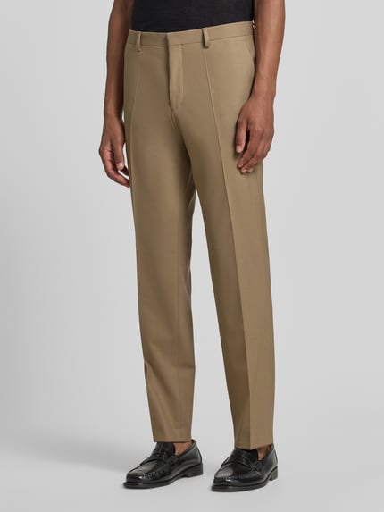 Männermodel trägt Super Slim Fit Anzughose aus Woll-Mix Modell 'Hesten253X' von HUGO in Beige, glatte Textur, Ganzkörperansicht von vorne, Herren Anzughose von HUGO
