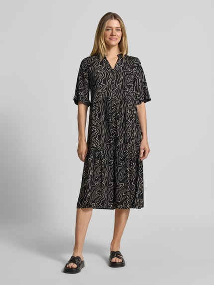Vrouwenmodel draagt Ausgestelltes Maxikleid aus reiner Viskose Modell 'EASY JOY' van Vero Moda met all-over print, maxi lengte, henley hals, korte knoopsluiting, 1/2-mouw, rechte zoom, materiaal viscose, uitlopend fit, vooraanzicht hele lichaam.