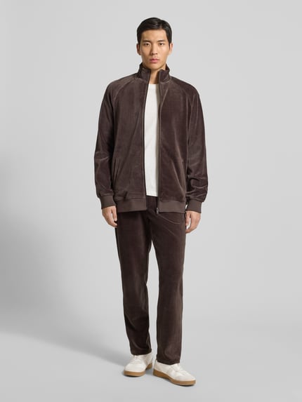 Männermodel trägt Sweatjacke mit Stehkragen von MCNEAL in Braun, Regular Fit, Reißverschluss, Gerippte Abschlüsse, Ganzkörperansicht von vorne.
