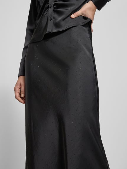 Kobiece modelka nosi Maxirock mit elastischem Bund od Neo Noir, czarny kolor, luźny krój, materiał z domieszką stretchu, zbliżenie na talię.