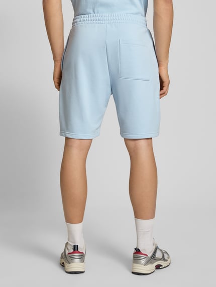 Männermodel trägt Regular Fit Shorts mit Label-Stitching von REVIEW in Hellblau, Baumwoll-Mix, Rückansicht Ganzkörperansicht