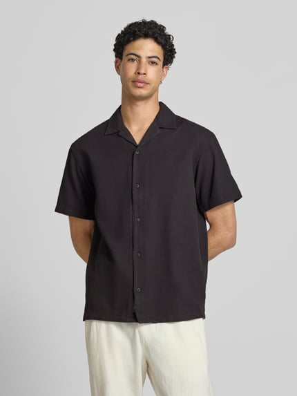 Männermodel trägt Regular Fit Freizeithemd mit Strukturmuster Modell 'Global' von Jack & Jones, Schwarz, Reine Baumwolle, kurzärmelig, Reverskragen, durchgehende Knopfleiste, Ganzkörperansicht von vorne.