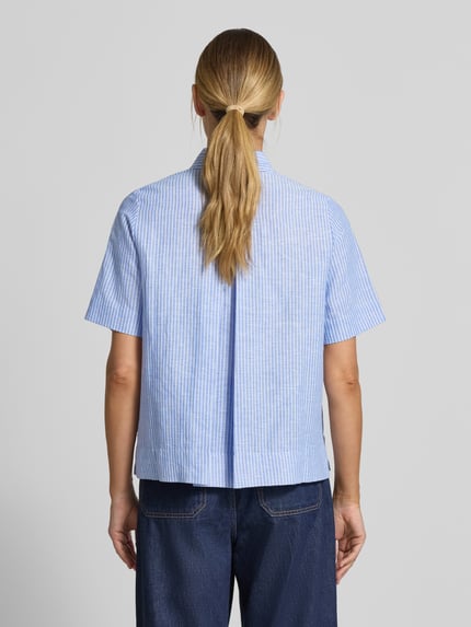 Frauenmodel trägt Regular Fit Leinenbluse mit Hemdblusenkragen von Christian Berg Woman, hellblau mit feinen Streifen, reine Leinen, Knopfleiste, Rückenlänge 61 cm, Ärmellänge 28 cm, Ganzkörperansicht Rückansicht.