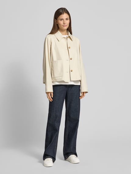 Frauenmodel trägt Relaxed Fit Trenchcoat aus reiner Baumwolle von Tommy Hilfiger in Beige, unifarben, Twill, wasserabweisend, Ganzkörperansicht von vorne.