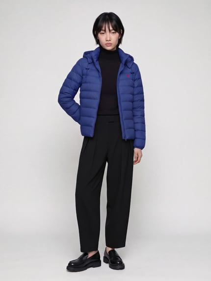 Frauenmodel trägt Steppjacke mit Kapuze von Polo Ralph Lauren in Dunkelblau, glatte Textur, schwarze Hose, Ganzkörperansicht von vorne, Damen Steppjacke von Polo Ralph Lauren