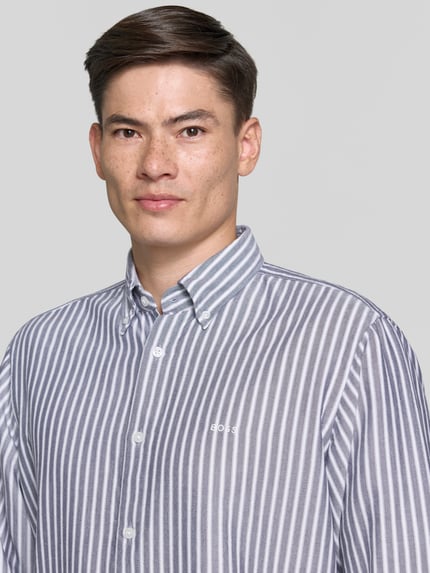 Männermodel trägt Regular Fit Freizeithemd aus Lyocell-Baumwoll-Mix Modell 'RICOPLUS' von BOSS Orange, gestreift, Nahaufnahme Oberkörper