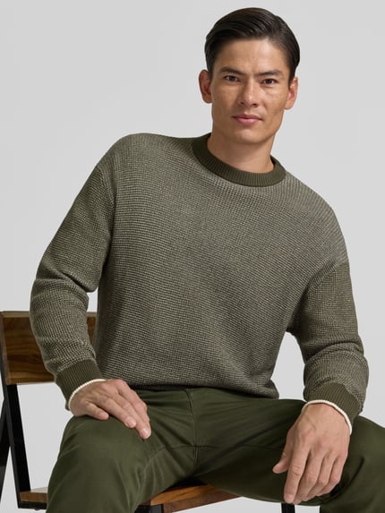 Männermodel trägt Regular Fit Strickpullover aus reiner Baumwolle von HECHTER PARIS in Olivgrün, Rundhalsausschnitt, Nahaufnahme Oberkörper.