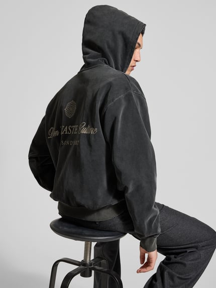 Männermodel trägt Oversized Jeansjacke aus Baumwoll-Mix von Don't Waste Culture, dunkle Farbe, elastische Abschlüsse, Rückenlänge 65 cm, Ganzkörperansicht Rückansicht.