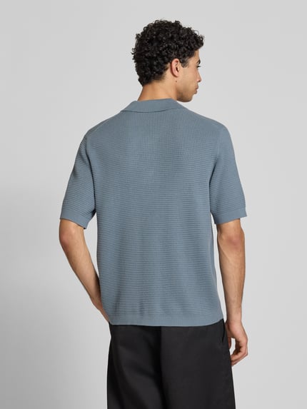 Männermodel trägt Regular Fit Poloshirt aus reiner Baumwolle von Marc O'Polo Denim, Optik: Unifarben, Strick, Label-Patch, Ganzkörperansicht Rückansicht.