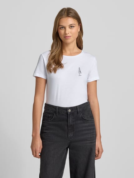 Frauenmodel trägt Regular Fit T-Shirt aus reiner Baumwolle Modell 'C_ELOVE_1' von BOSS Orange in Optik: Unifarben mit Label-Stitching-Applikation, Motiv-Stitching, Rundhals-Ausschnitt, Kurzarm, Materialverarbeitung: Jersey, Farbe Weiß, glatte Struktur, Ganzkörperansicht von vorne.