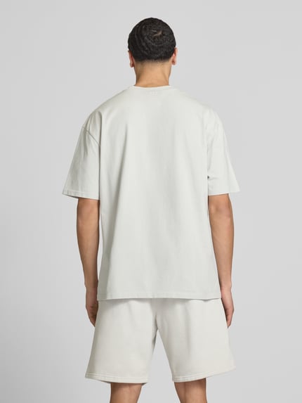 Männermodel trägt Oversized T-Shirt mit Logo-Stitching von Pegador, Reine Baumwolle, Oversized-Fit, Rundhalsausschnitt, Rückenlänge 73 cm, Ganzkörperansicht Rückansicht