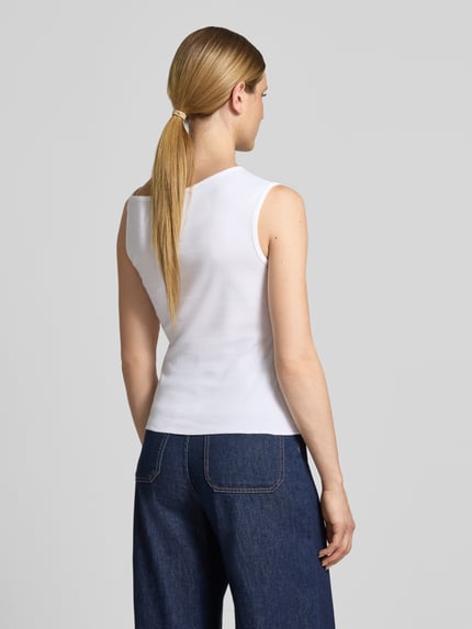 Frauenmodel trägt Regular Fit Top aus reiner Baumwolle Modell 'BAGAGLI' von MAX&Co., weiß, kombiniert mit dunkelblauer Jeans, Ganzkörperansicht Rückansicht.