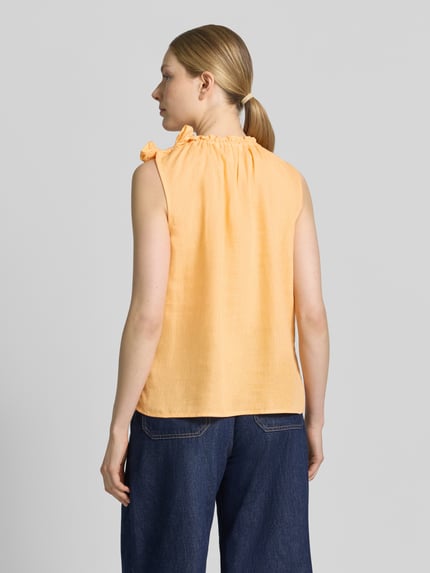 Vrouwenmodel draagt Regular Fit blouse uit viscosemix met linnen aandeel van Christian Berg Woman, met sierstrik, opstaande kraag met ruches, mouwloos design, kleur lichtoranje, ruglengte maat 36: 54 cm, mix van viscose en linnen, ganzkörperansicht rückansicht.