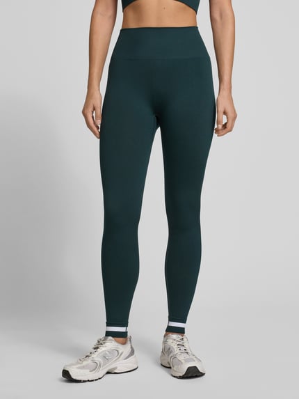Kobiece modelka nosi Regular Fit Leggins mit breitem Bund od The Upside, ciemnozielony, elastyczna tkanina, pełny przód, zbliżenie na nogi.