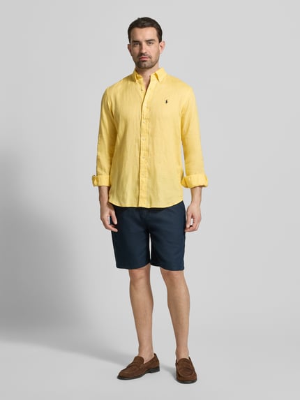 Männermodel trägt Regular Fit Freizeithemd aus reinem Leinen von Polo Ralph Lauren in Gelb, einreihige Knopfleiste, Logo-Detail, Ganzkörperansicht von vorne.