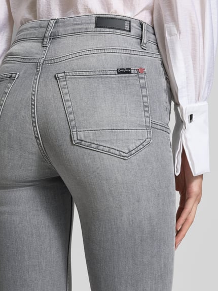 Frauenmodel trägt Slim Fit Jeans aus Baumwoll-Elasthan-Mix von Cars Jeans, Modell 'JOYCE', grauer Farbton, 5-Pocket-Design, Detailaufnahme der Rückansicht.