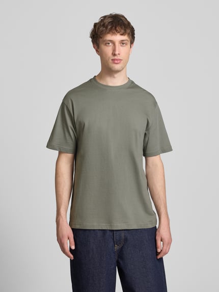 Männermodel trägt Relaxed Fit T-Shirt aus reiner Baumwolle Modell 'FRED LIFE' von Only & Sons, unifarben, Rundhals, Kurzarm, Ganzkörperansicht von vorne.