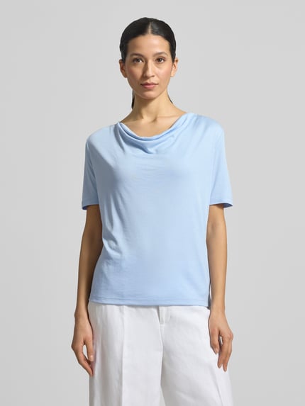 Frauenmodel trägt T-Shirt mit Wasserfall-Ausschnitt von More & More in Hellblau aus Viskose-Mix, Regular Fit, Ganzkörperansicht von vorne.
