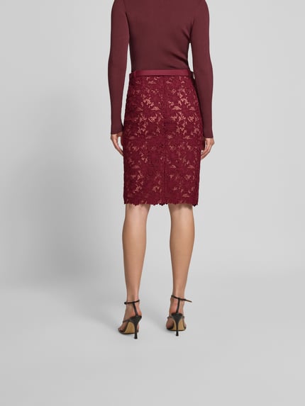 Vrouwenmodel draagt Slim Fit Rock met all-over kant van Self-Portrait in bordeauxrood, knielengte, afneembare riem, onderrok, volledige achterkantaanzicht.