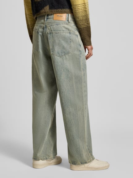 Männermodel trägt Wide Fit Jeans im Used-Look von ANOTHER COTTON LAB, Baumwoll-Mix mit Viskose-Anteil, Eingrifftaschen, Ganzkörperansicht Rückansicht.