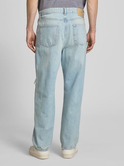 Männermodel draagt Loose Fit Jeans aus reiner Baumwolle Modell 'FADE' van Only & Sons in denimlook met destroyed-detail en labelpatch, ganzkörperansicht rückansicht.