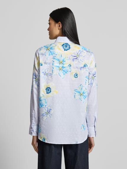 Vrouwenmodel draagt Regular Fit Hemdbluse aus reiner Baumwolle van Christian Berg Woman met all-over bloemenmotief, overhemdkraag, puur katoen, met lange mouwen, ruglengte maat 36: 58 cm, mouwlengte maat 36: 61 cm, bloemenprint in blauw en geel op wit, ganzkörperansicht rückansicht.