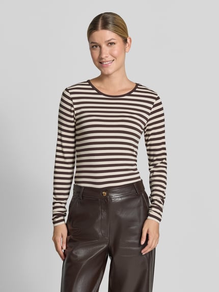 Frauenmodel trägt Skinny Fit Longsleeve aus Viskose-Elasthan-Mix, Modell 'Liana' von FREE/QUENT, braun-beige gestreift, Rundhalsausschnitt, Rückenlänge bei Größe S 61 cm, Ganzkörperansicht von vorne.