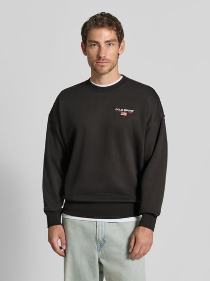 Männermodel trägt Relaxed Fit Sweatshirt aus Baumwoll-Mix von Polo Ralph Lauren in Schwarz mit kleinem Logo-Print, Ganzkörperansicht von vorne.