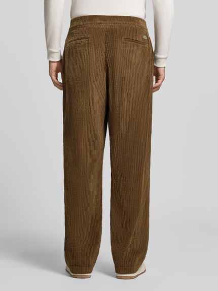 Männermodel trägt Regular Fit Hose mit seitlichen Eingrifftaschen von Lacoste, brauner Cord mit Struktur, Unifarbe, Ganzkörperansicht Rückansicht