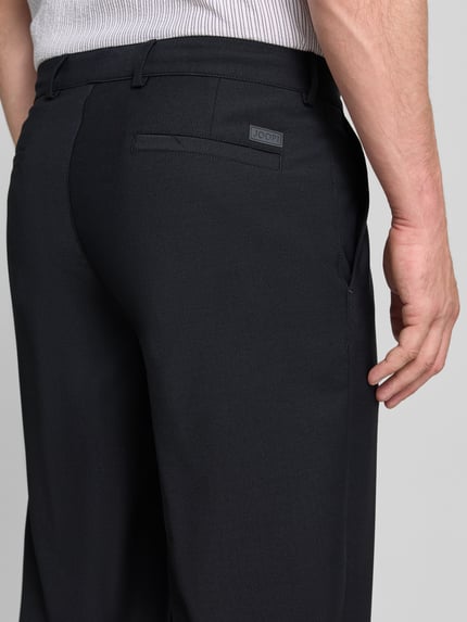 Mężczyznamodel nosi spodnie Loose Fit Hose mit Bügelfalten Modell 'Lexter' od JOOP! z mieszanki materiałów z dodatkiem wełny, czarne, gładka tekstura, tylna perspektywa, detailaufnahme