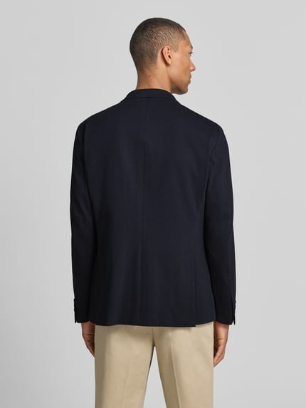Männermodel trägt Modern Fit Sakko mit Brustleistentasche von Pierre Cardin in Dunkelblau, Baumwoll-Mix, Rückenlänge 73 cm, Ganzkörperansicht Rückansicht.