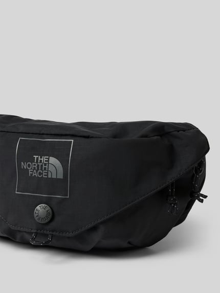 Produktfoto, schwarze Bauchtasche mit Logo-Print Modell 'Glen' von The North Face, Reißverschluss, glatte Textur, grauer Hintergrund