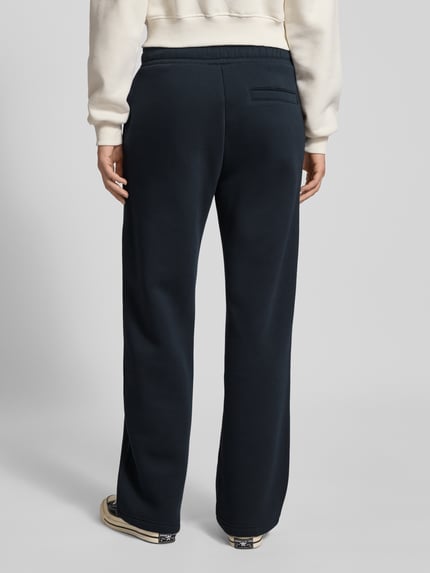 Frauenmodel trägt Straight Leg Sweatpants mit Logo und elastischem Bund von Review, dunkelblauer Baumwoll-Mix, Ganzkörperansicht Rückansicht