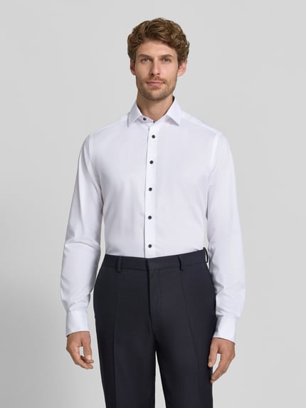 Männermodel trägt weißes Modern Fit Businesshemd mit extra langem Arm von OLYMP, glatte Textur, schwarze Knöpfe, Ganzkörperansicht von vorne, Herren Businesshemd von OLYMP