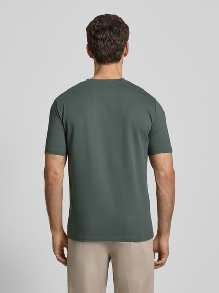 Männermodel trägt T-Shirt mit Label-Print von MARC O'POLO in Unifarbenes-Design aus Reine Baumwolle, gerader Schnitt, Ganzkörperansicht Rückansicht.
