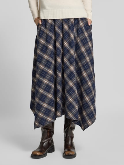 Frauenmodel trägt Midi-Rock mit asymmetrischem Saum Modell 'VMTILDA' von VERO MODA, kariertes Allover-Muster, Webware, Ganzkörperansicht von vorne.