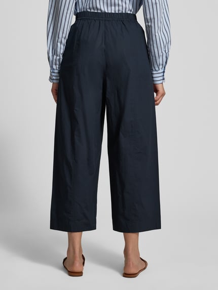 Frauenmodel trägt Hose mit elastischem Bund von Lanius aus reiner Baumwolle in Dunkelblau, Relaxed Fit, Ganzkörperansicht Rückansicht.