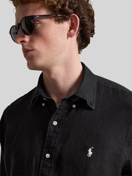 Männermodel trägt Regular Fit Freizeithemd aus reinem Leinen von Polo Ralph Lauren, Optik: Unifarben, Flammgarn, Nahaufnahme Oberkörper.