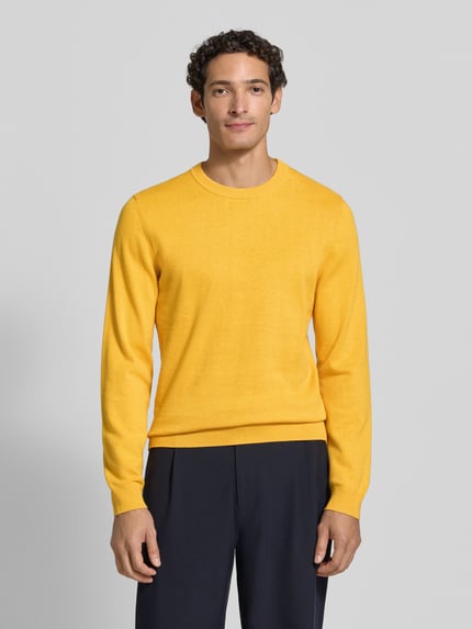 Männermodel trägt Strickpullover aus Baumwoll-Kaschmir-Mix mit Rundhalsausschnitt von MCNEAL in Gelb, Regular Fit, Ganzkörperansicht von vorne. Rückenlänge 70 cm, Ärmellänge 74 cm.