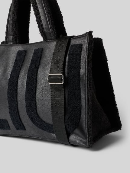 Produktfoto, Tote Bag mit Logo-Detail Modell 'Montone' von Liu Jo White, schwarze Lederoptik, Teddyfellbesatz, sichtbares Logo, matte Struktur