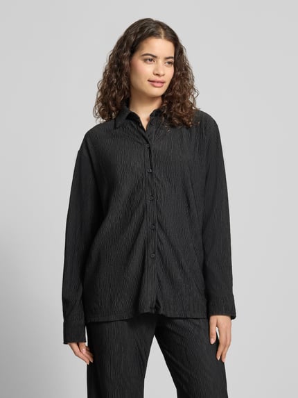 Frauenmodel trägt Relaxed Fit Bluse mit Strukturmuster von REVIEW in Schwarz mit Hemdblusenkragen, Knopfleiste, Material-Mix mit Stretch-Anteil, Ganzkörperansicht von vorne.