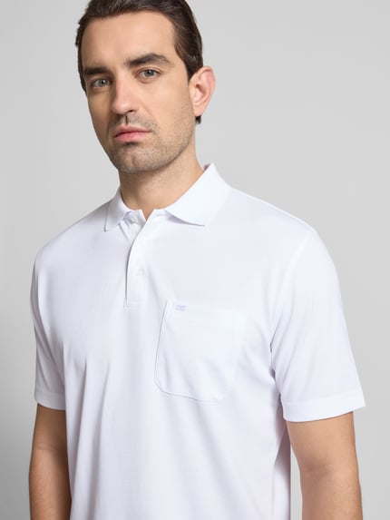 Männermodel trägt Regular Fit Poloshirt mit Brusttasche von Christian Berg Men, weiß, Polokragen, Knopfleiste, Baumwoll-Mix, Nahaufnahme Oberkörper.