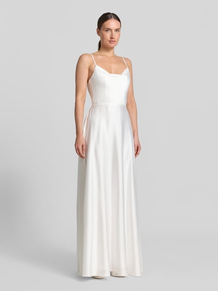 Frauenmodel trägt Abendkleid mit Spaghettiträgern von Laona in Weiß, A-Linie, Maxikleid, Reißverschluss auf der Rückseite, Ganzkörperansicht von vorne. Rückenlänge bei Größe 36: 111 cm, Brustweite bei Größe 36: 41 cm, Oberteil zum Binden.