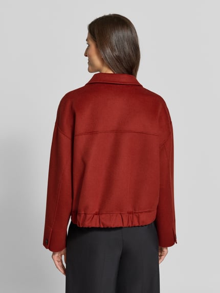 Frauenmodel trägt Jacke aus Schurwolle mit Pattentaschen von windsor. in Rot, Regular Fit, strukturierte Oberfläche, Ganzkörperansicht Rückansicht.