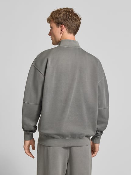 Männermodel trägt Relaxed Fit Sweatshirt aus Baumwoll-Mix von PEGADOR in Grau mit Troyer-Kragen, Logo-Stickerei, Ziernähten, Rückenansicht, Ganzkörperansicht Rückansicht.