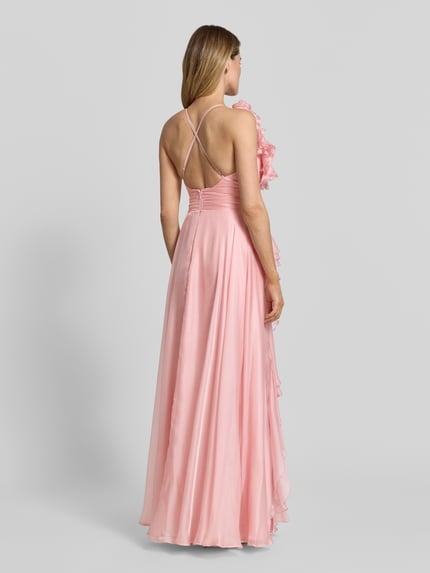 Modelka kobieca nosi 'Abendkleid mit Volants und Herz-Ausschnitt' od V.M., satyna, A-linia, róż, długie, ramiączka krzyżowane z tyłu, falbany, zamek z tyłu, długość pleców w rozmiarze 36: 122 cm, szerokość w rozmiarze 36: 32 cm, widok całej sylwetki z tyłu.