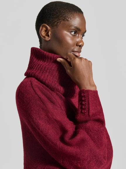 Frauenmodel trägt Relaxed Fit Strickpullover mit Rollkragen Modell 'IHKAMARA' von ICHI in dunklem Rot, strukturierte Oberfläche, Material-Mix mit Alpaka-Anteil, elastische Abschlüsse, Nahaufnahme Oberkörper, Rückenlänge 63 cm, Ärmellänge 72 cm.