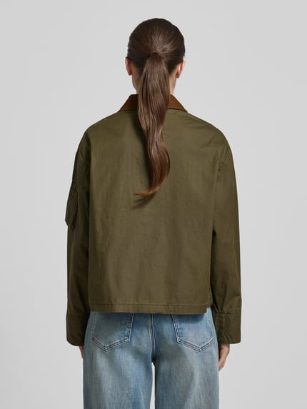 Modelka kobieca nosi Jacke aus Baumwolle mit Pattentaschen von Original Bombers, kolor kaki, krój regular fit, widok całej sylwetki z tyłu.
