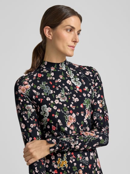 Frauenmodel trägt Slim Fit Midikleid mit Stehkragen von Marc Cain im floralen Allover-Print, elastischer Material-Mix, Nahaufnahme Oberkörper.