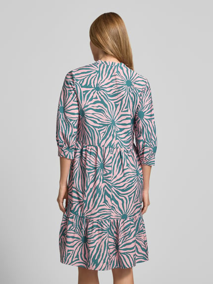 Vrouwenmodel draagt Relaxed Fit midi-jurk uit viscosemix met tuniekhals, knoopsluiting, halflange mouwen van Christian Berg Woman, ruglengte maat 36: 106 cm, borstwijdte maat 36: 48 cm, mouwlengte maat 36: 45 cm, kleurrijk zebrapatroon, geheelbeeld achteraan.